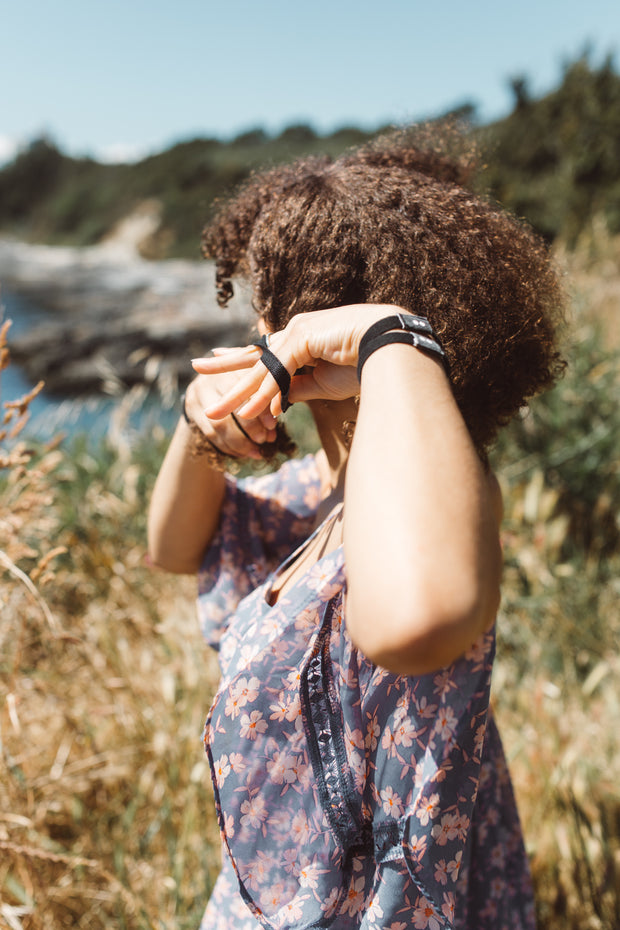 Girl putting on Kooshoo black hair ties. Available for purchase on The Conservationist. 
