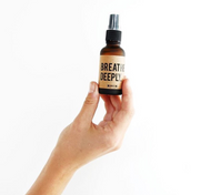 A person's hand holding the Breathe Deeply Mini. This shows the smaller size of the aromatherapy mist. Available for purchase on The Conservationist. 