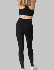 The Conservationist: Eco-friendly black leggings made out of post consumer recycled plastic. Back facing image of  black leggings. 
