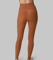 The Conservationist: Eco-friendly turmeric leggings made out of post consumer recycled plastic. Back facing image of leggings.