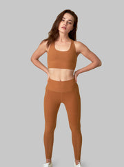 The Conservationist: Eco-friendly turmeric leggings made out of post consumer recycled plastic. Front facing image of leggings. 